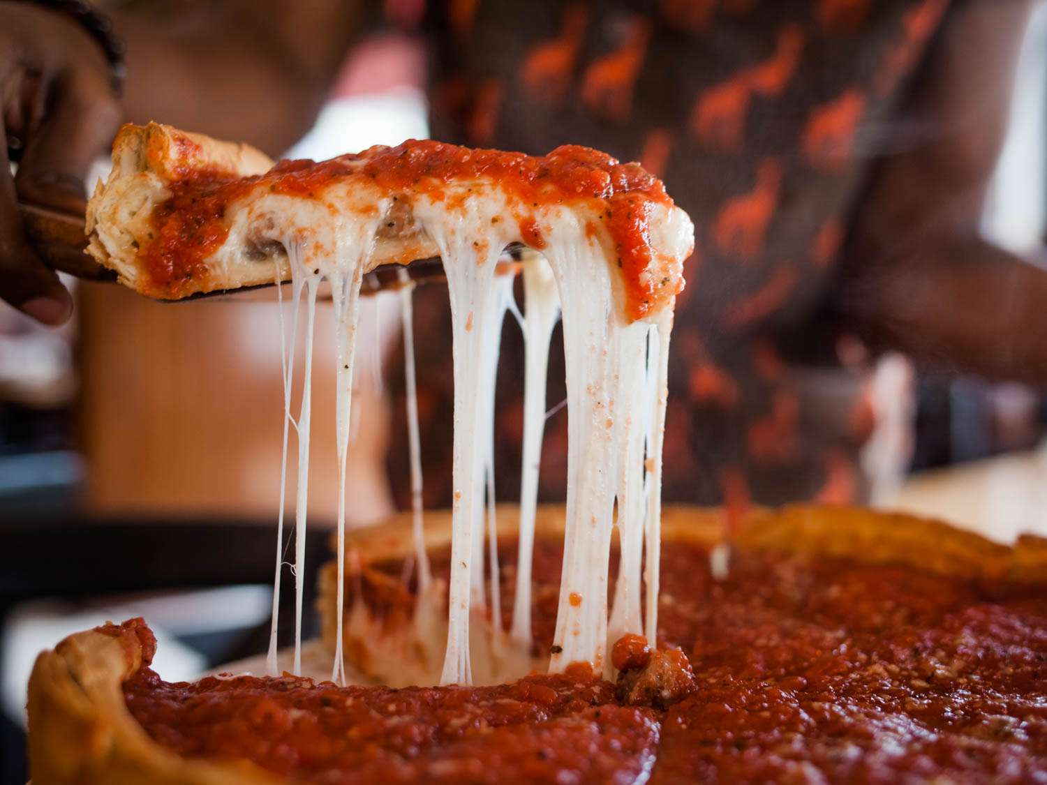 A slice is served from a deep dish pizza at Giordano's.