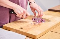 A person dices red onion using the Misono 8.2 Inch Molybdenum Gyutou