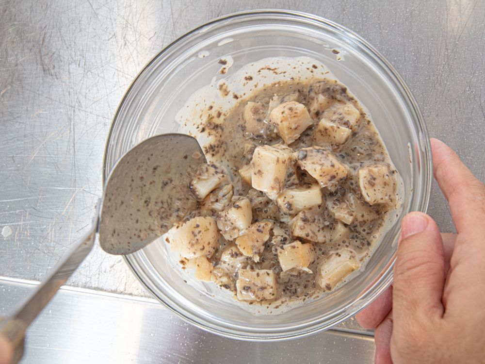 Overhead view of mixing scallops with sauce