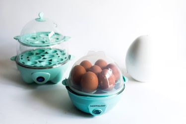 A collection of three egg cookers on a white background