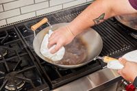 Person cleaning a Joyce Chen Carbon Steel Wok