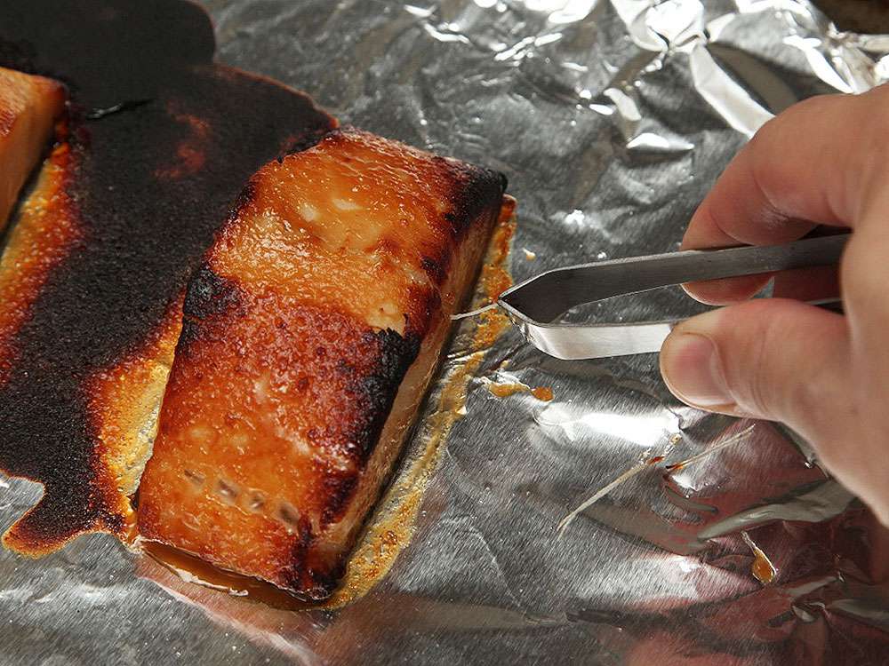 Pulling out the pin bones from a finished black cod fillet with fish tweezers.