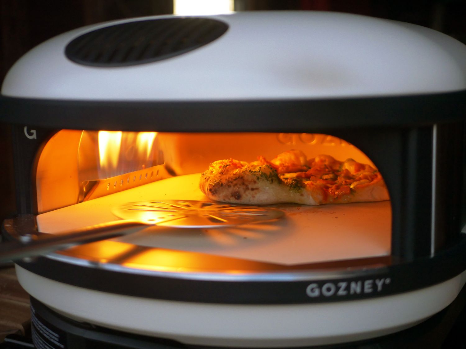 a turner reaching inside the arc to rotate a pizza