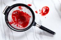 KitchenAid Classic Strainer with red puree and spills on a countertop