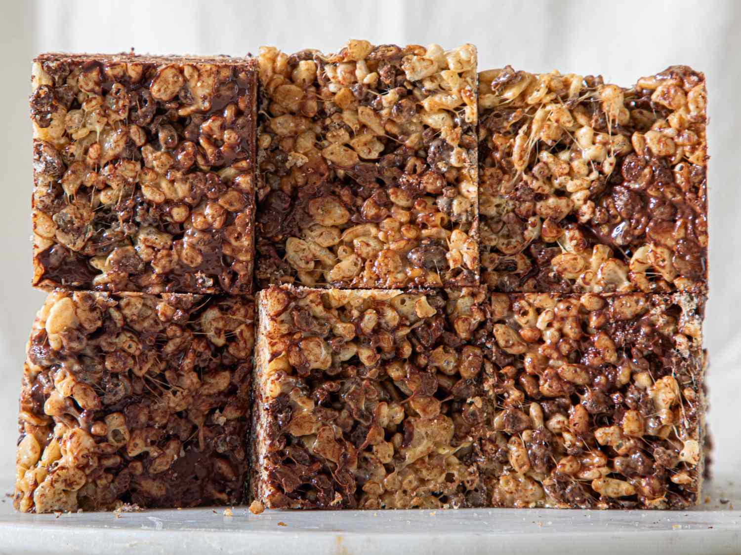 Malted rice krispies squares arranged in two rows of three on a flat surface