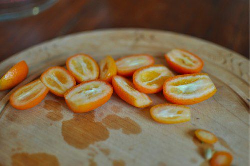 Kumquat halves on a cutting board.