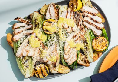 Grilled chicken caesar salad on a platter.