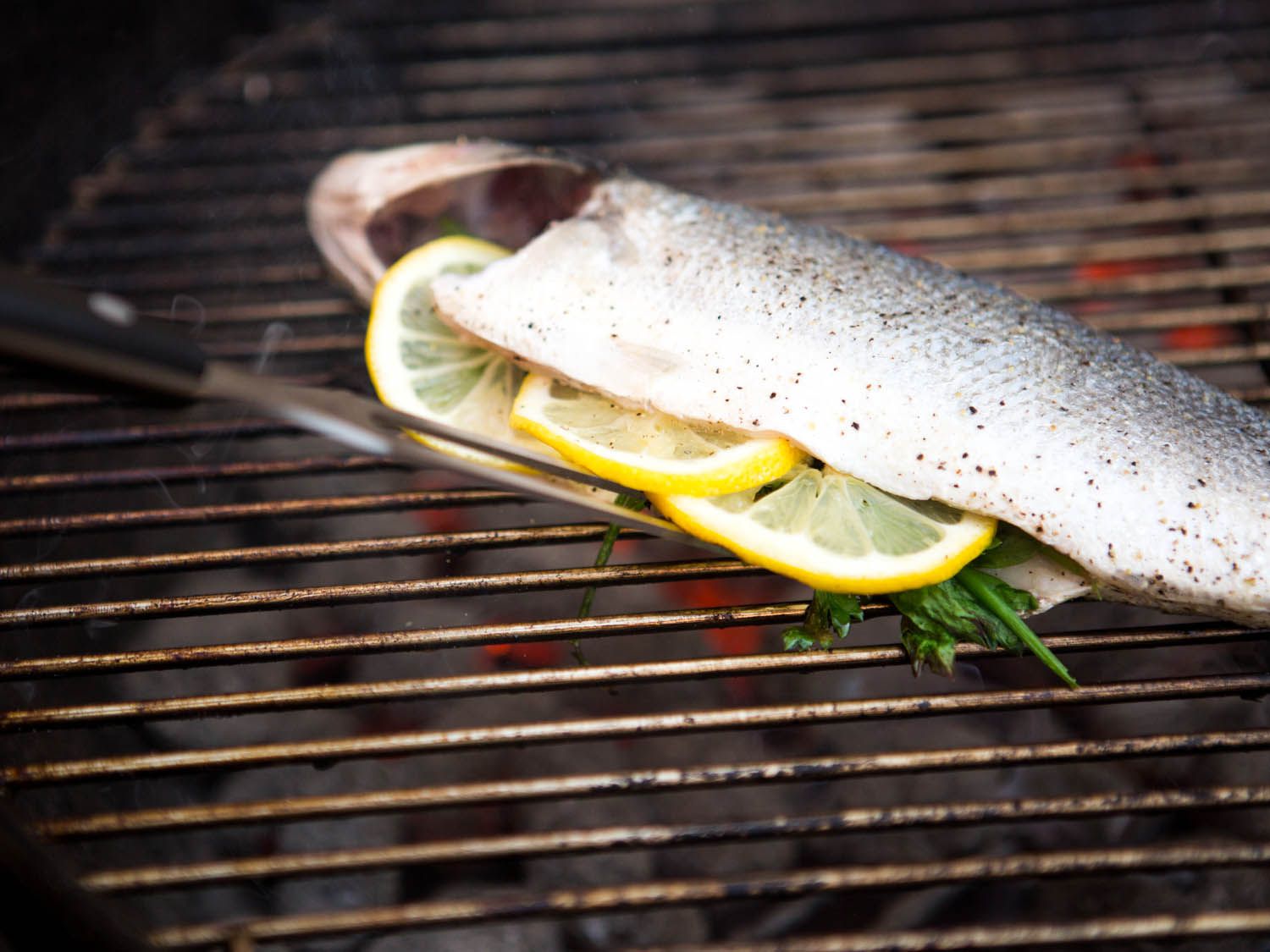 The tines of the carving fork are brought into contact with the fish.