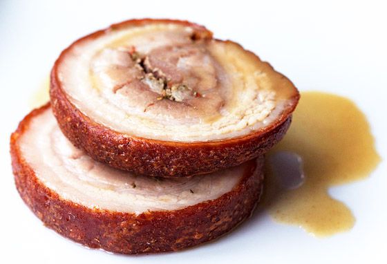 two slices of all-pork belly porchetta plated with jus