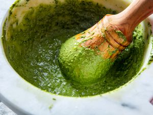 A classic Genovese-style pesto sauce made in a granite mortar with a wooden pestle.
