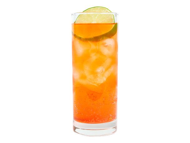 Aperol spritz cocktail in tall glass with ice and lemon wedge garnish.