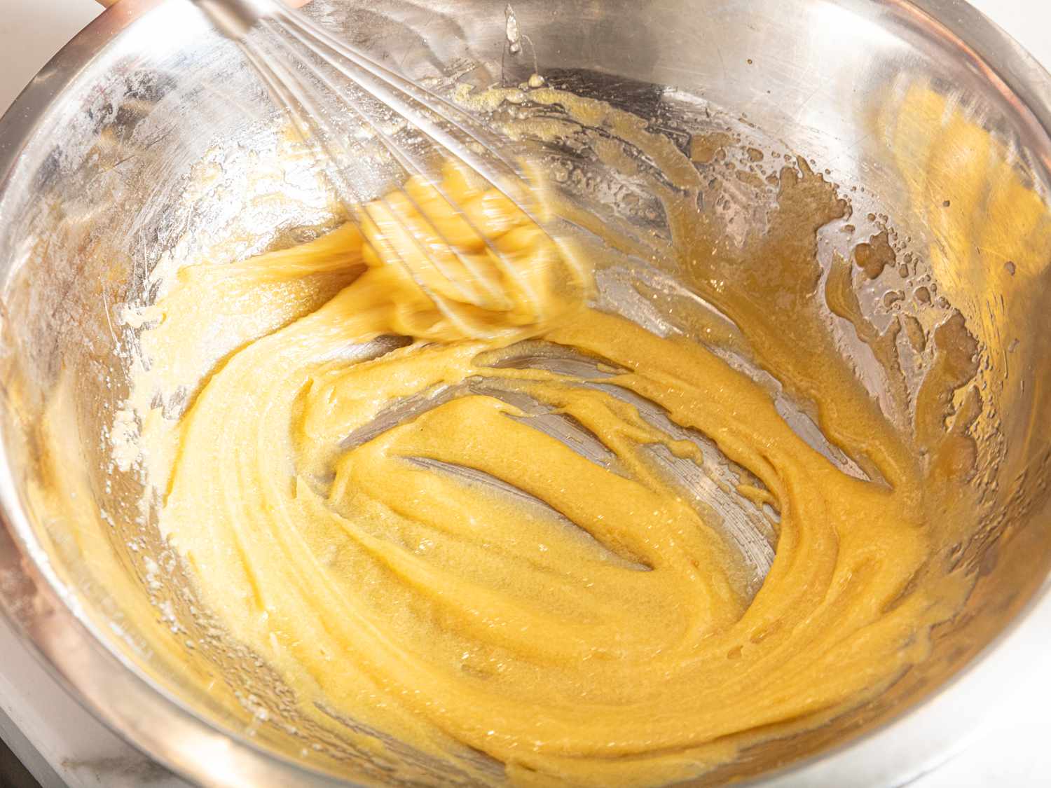 Side view of whisking dough