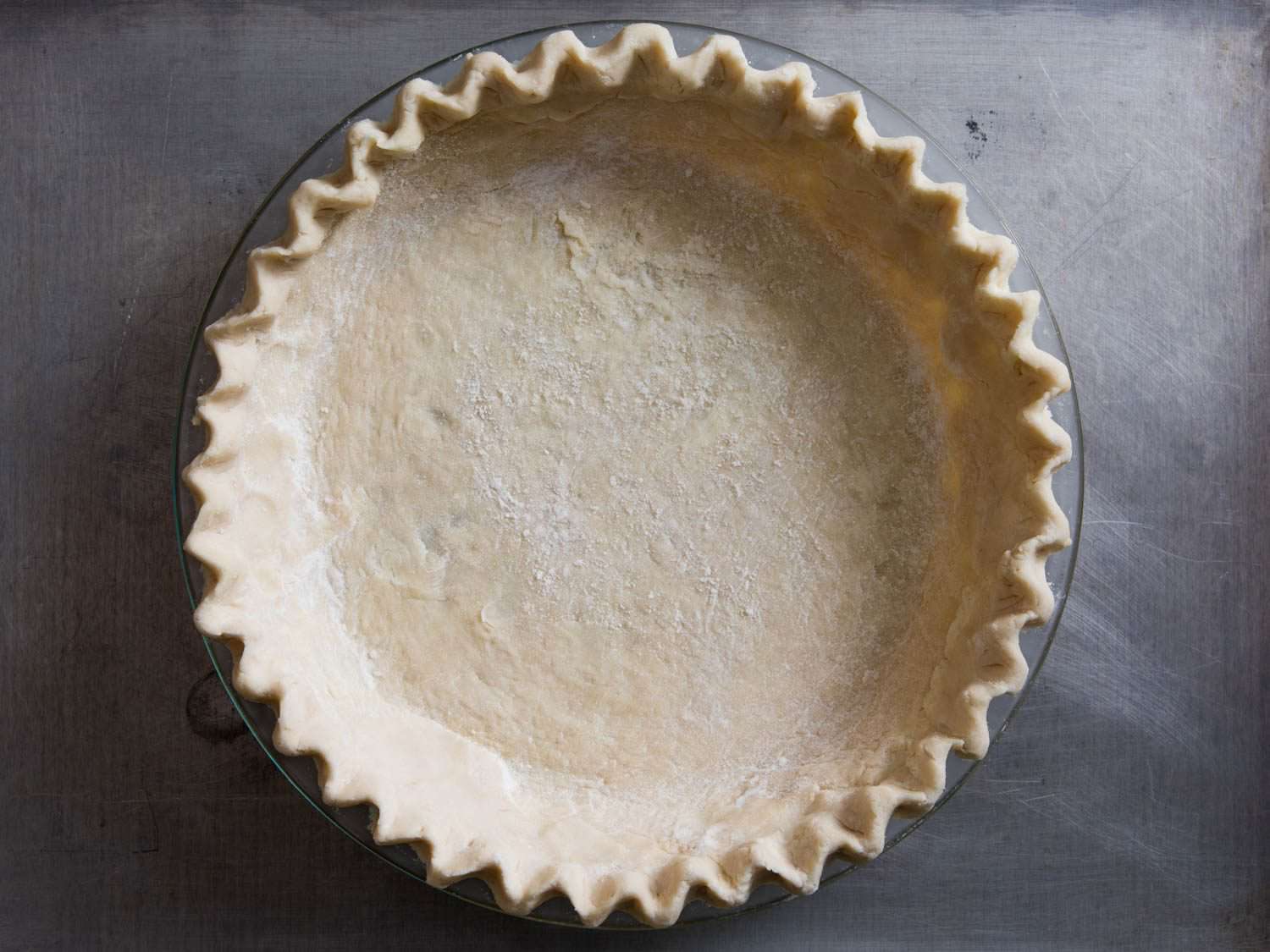Formed and uncooked pie dough in a glass plate.