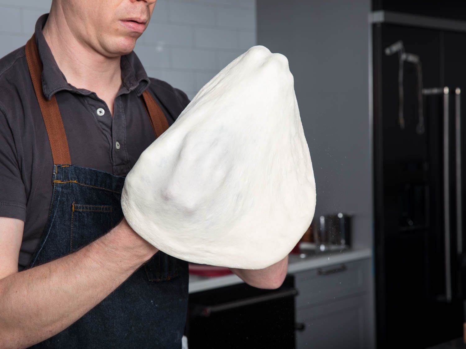 Stretching pizza dough by hand.