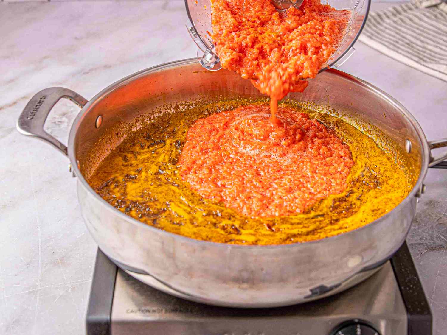 Side view of adding vegetable puree to onion mixture 
