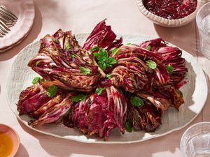 A platter of grilled radicchio garnished with fresh herbs, placed on a set table