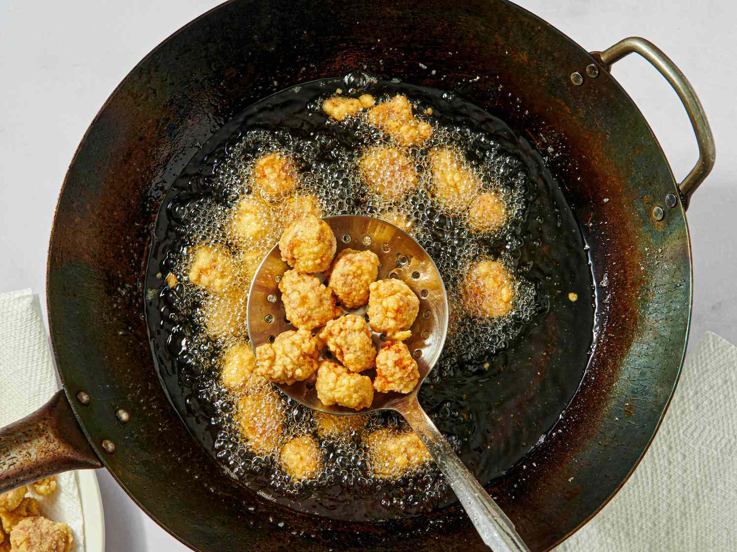 Sweet and sour pork balls being fried in a wok