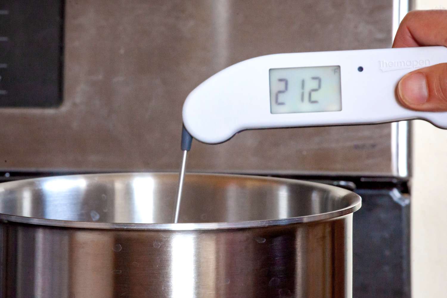 A person taking the temperature of a pot of boiling water with the Thermapen ONE.