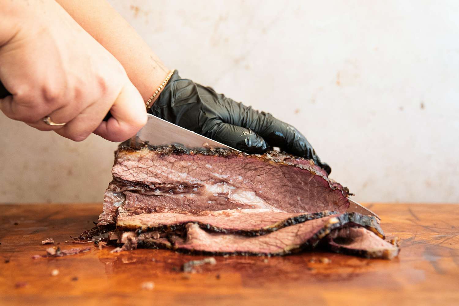 A person slicing meat using the Wusthof Classic Carving Knife