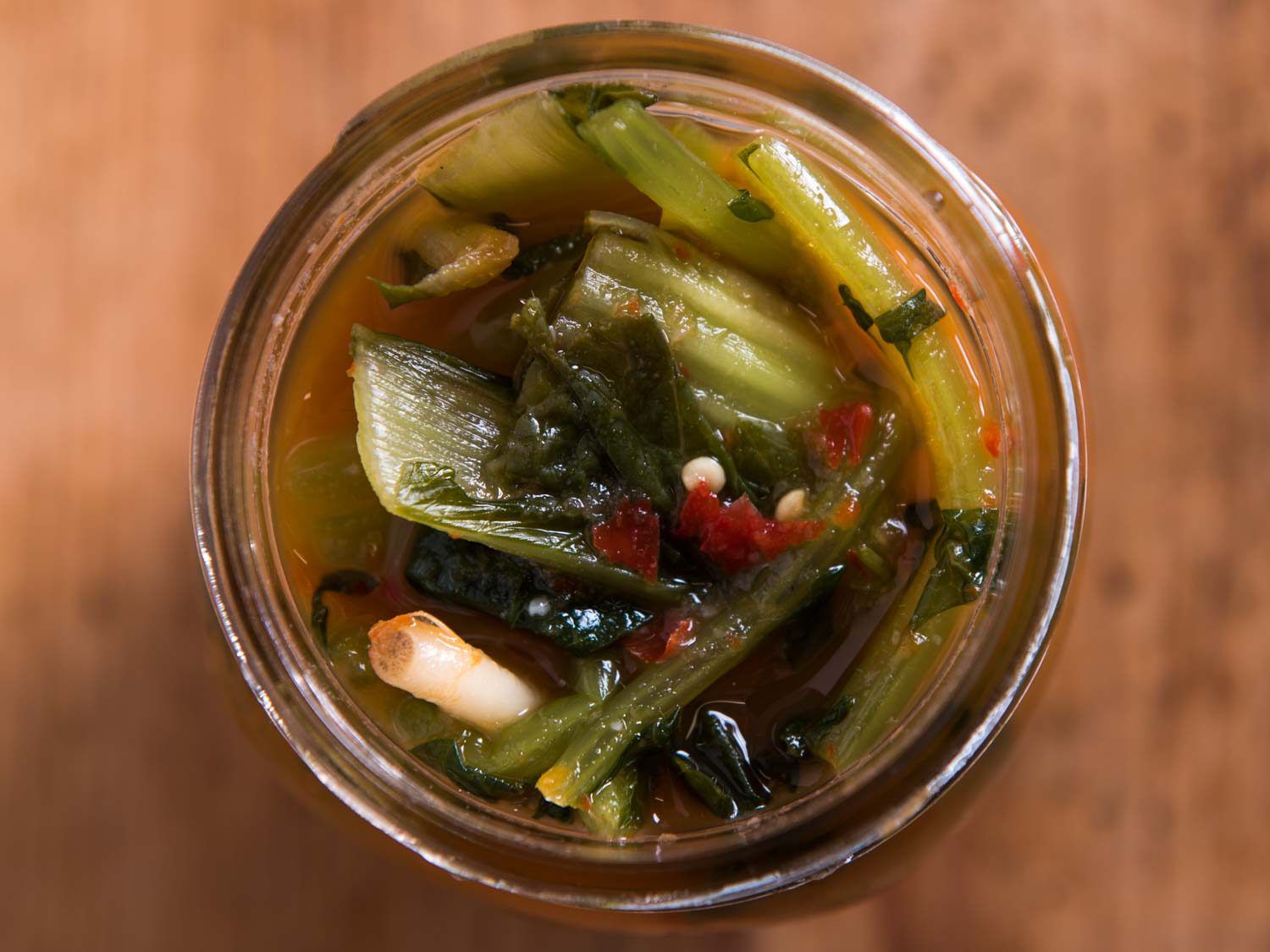 Young radish greens kimchi fermenting in a jar. 