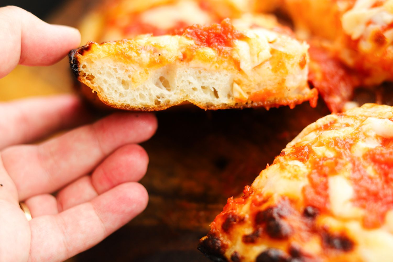 A closeup of pizza made in the LloydPans Kitchenware 10 by 14 Inch Detroit Style Pizza Pan