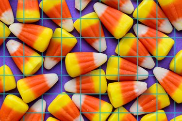 Pattern of candy corn on a purple grid background