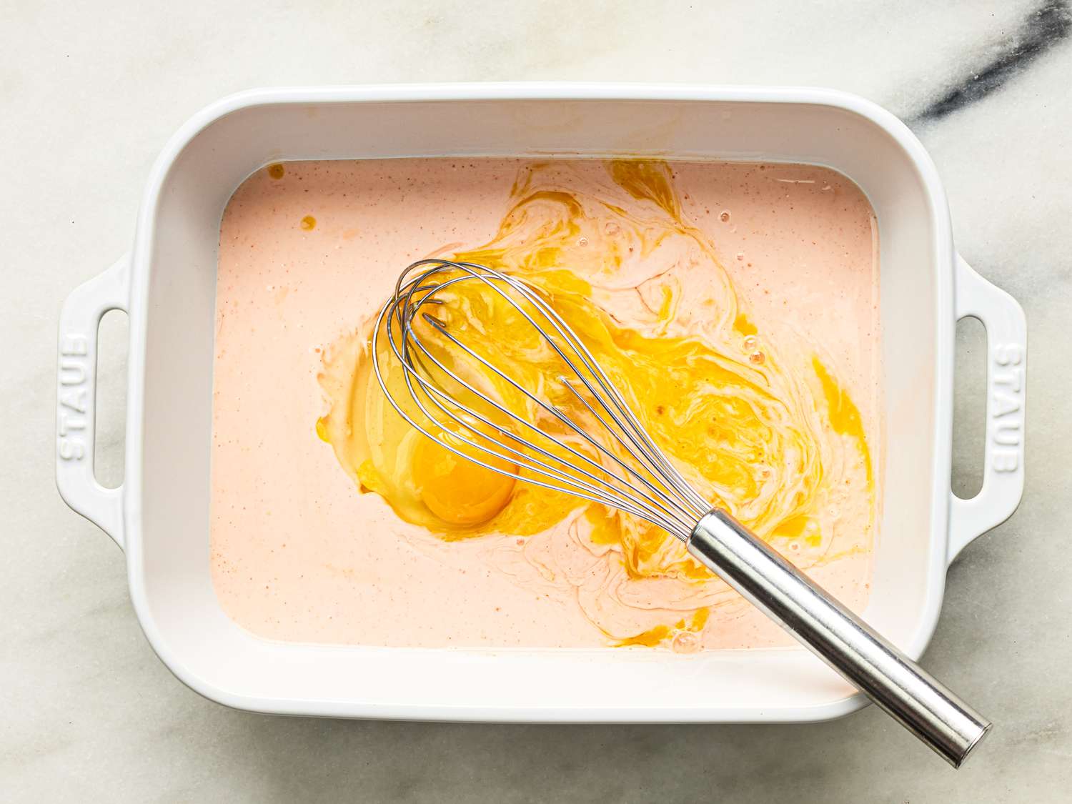 Overhead view of whisking egg into buttermilk mixture