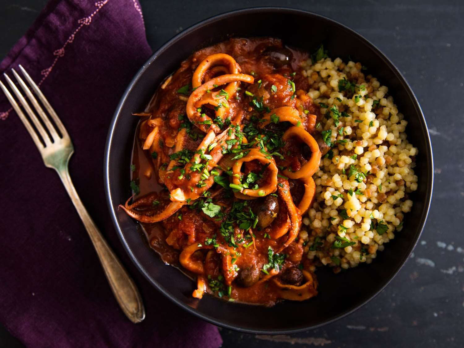 Braised squid with tomato sauce and harissa, served on fregola.