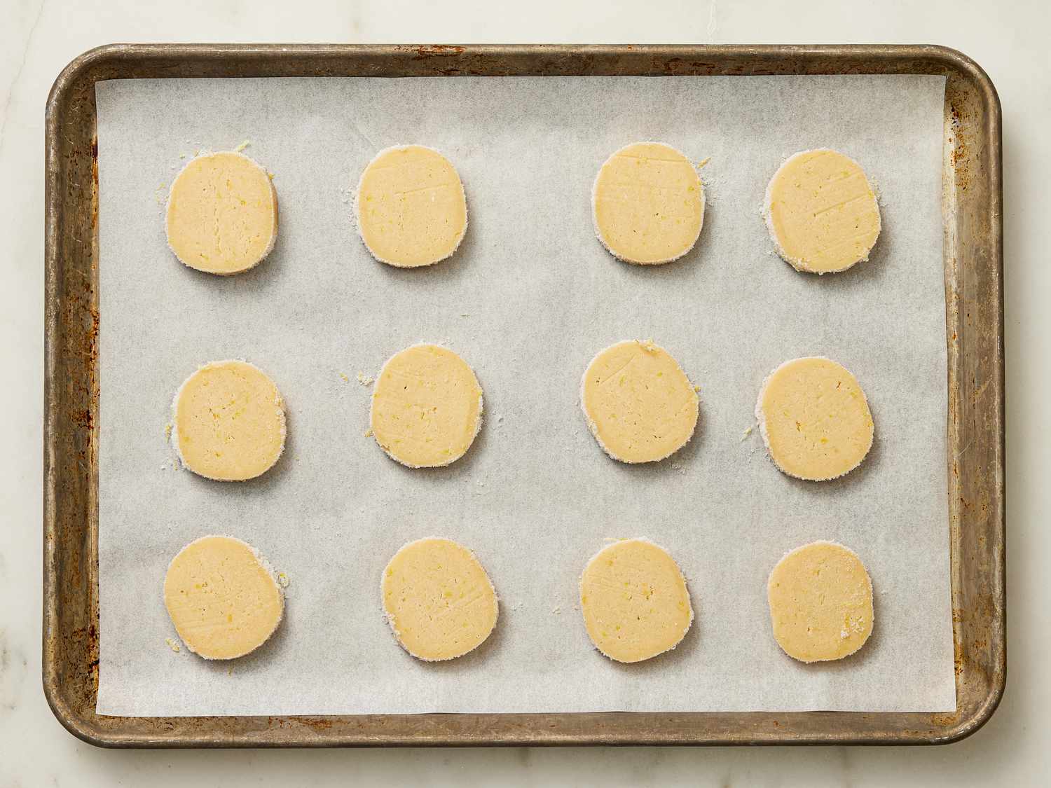 Cookies evenly spaced on a parchment paper lined sheet pan 