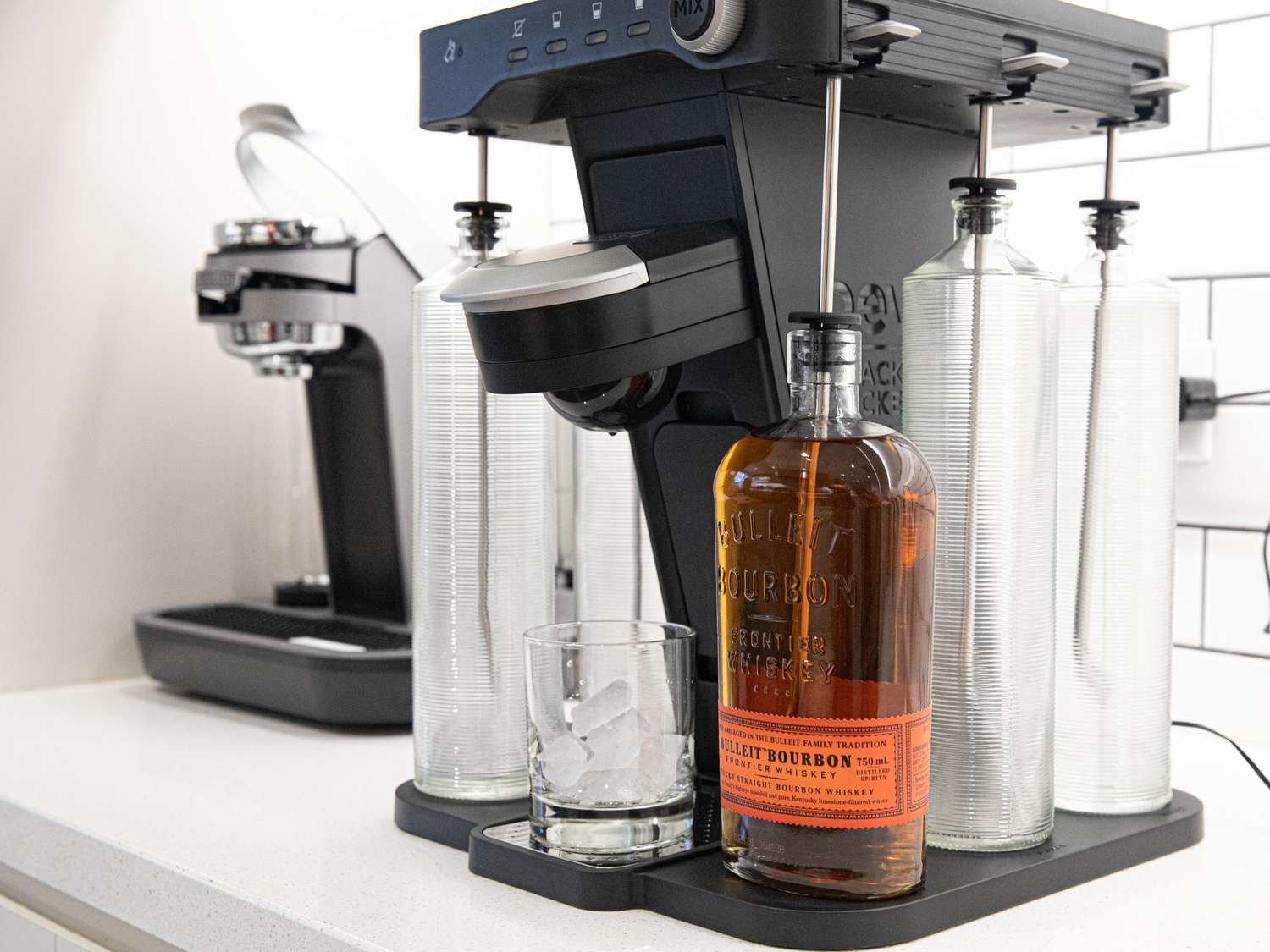 The Bev cocktail machine with a bottle of bourbon loaded in it 