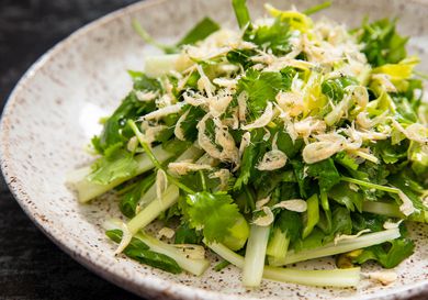 Closeup of tiger salad, served on a speckled earthen ware plate.
