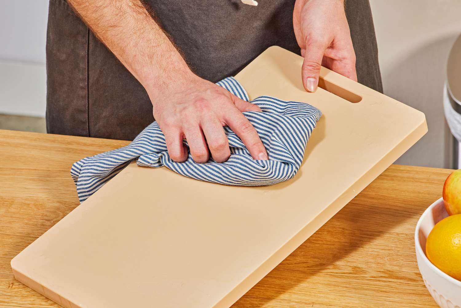 A person wiping down the Hayate cutting board.