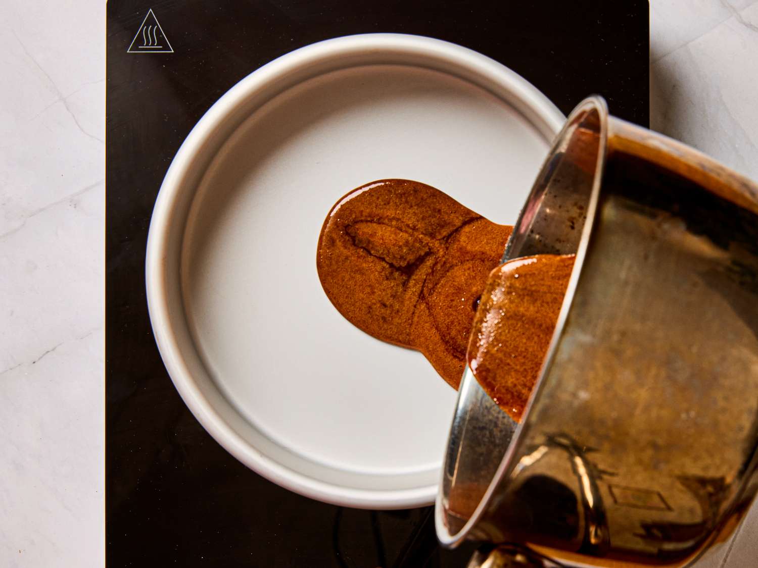 Pouring caramel into a round dish