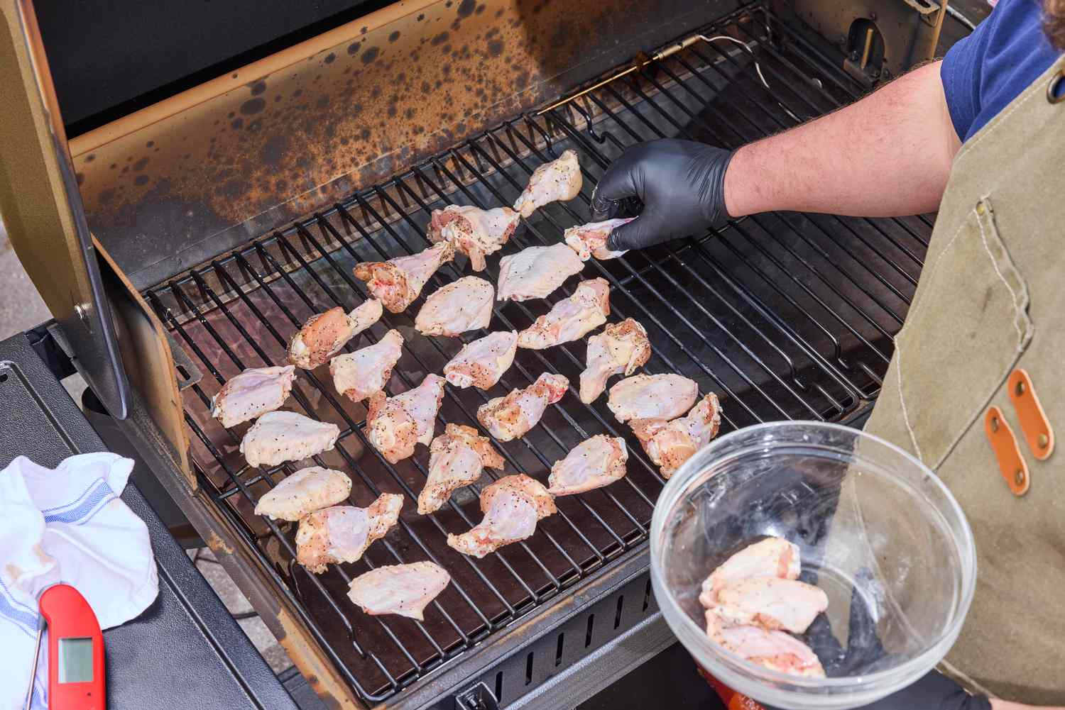 A person cooks wings in the Traeger Woodridge Pro