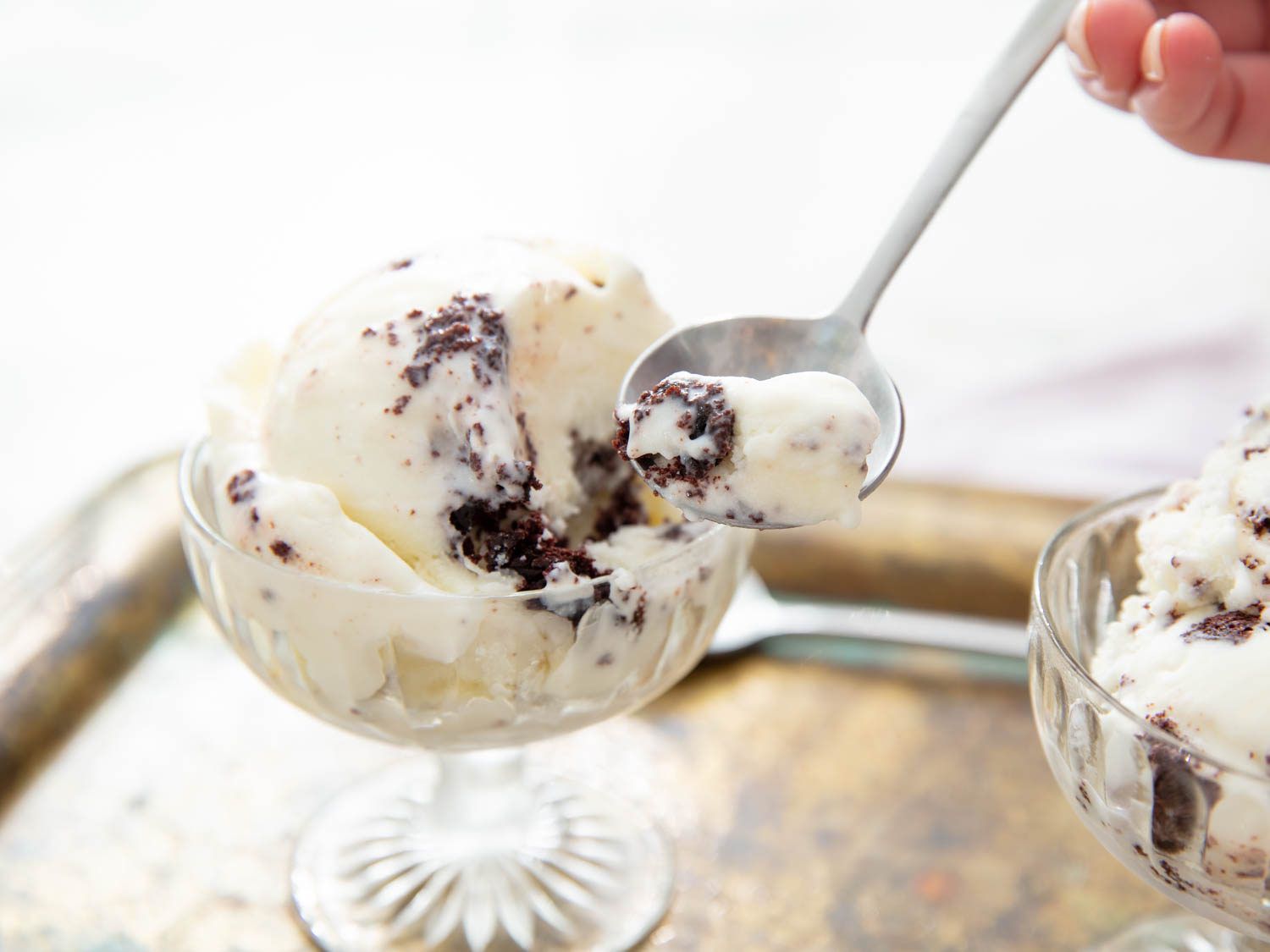 Spooning a bite of cake scrap ice cream from a dish.