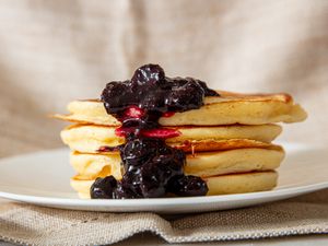 A stack of lemon ricotta pancakes topped with a blueberry compote