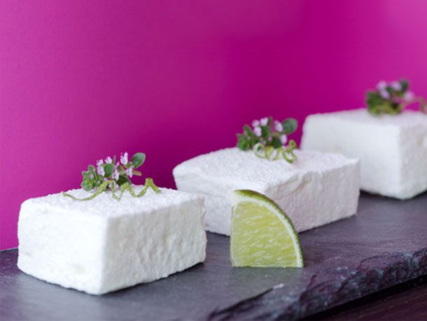 Pisco sour marshmallows on a piece of slate with a wedge of lime