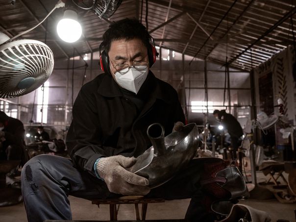 A factory worker examining a hand made wok