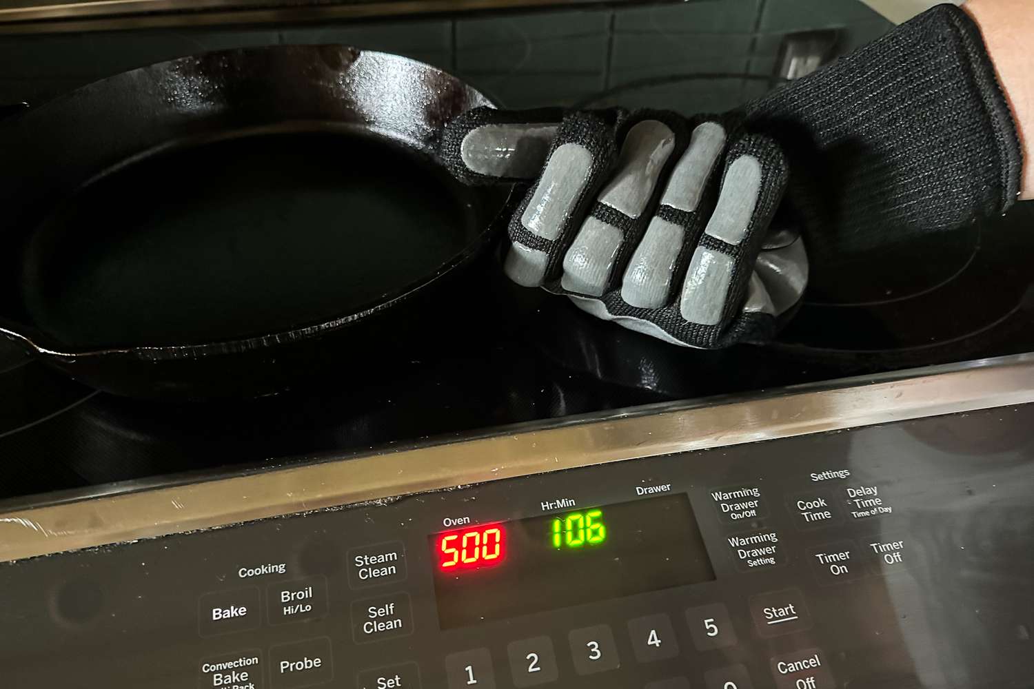 A person holds up a pan while wearing the Blackstone Griddle Gloves