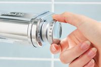 Closeup of hand adjusting knob on KitchenAid pasta roller attachment