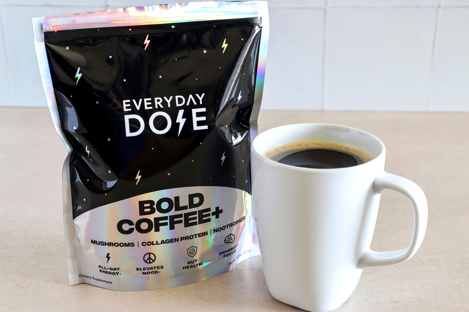 A package labeled 'Everyday Dose Bold Coffee+' next to a mug of coffee