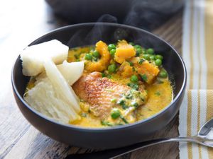a bowl of chicken with aji amarillo and coconut milk