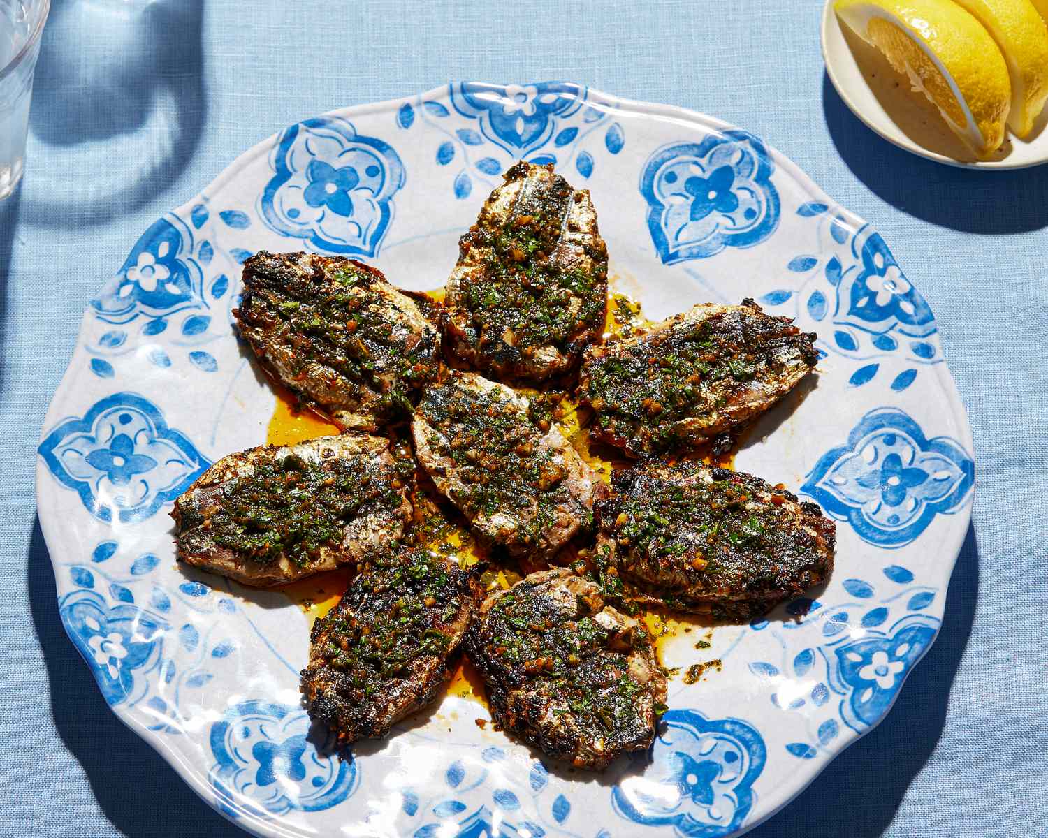 Cooked chermoula sardines arranged on a decorative plate with a garnish