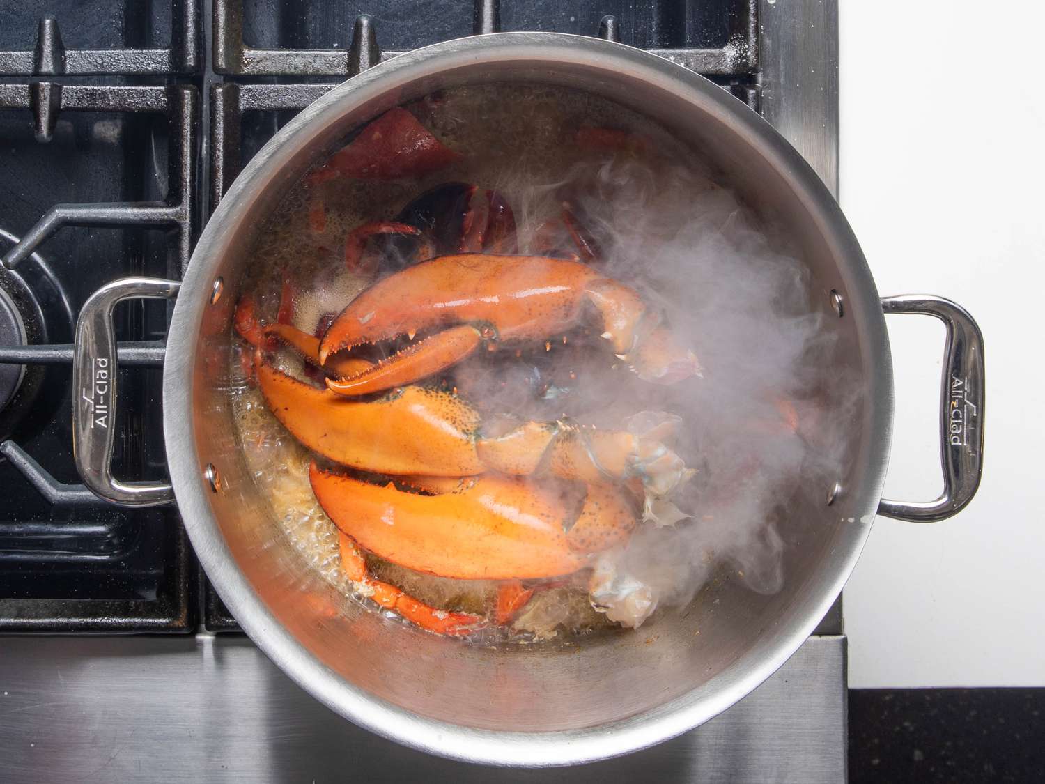 Lobster claws sit on top of the shells in the stock, but don't sink into the liquid.
