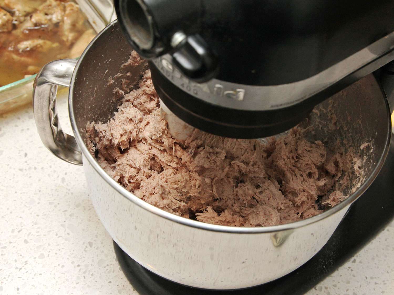 The pork is whipped with the paddle attachment in a stand mixer.