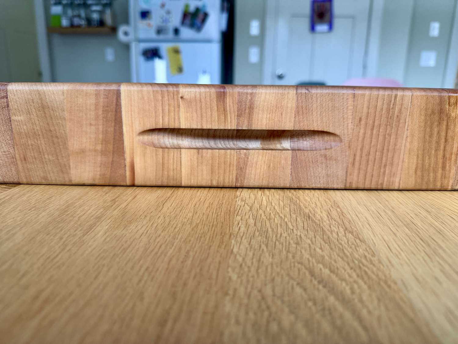 A closeup of the finger grooves of a wooden cutting board