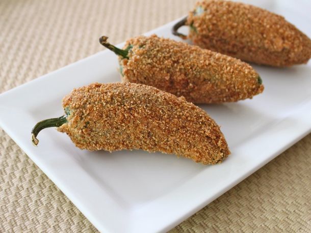Three jalapeño poppers on a rectangular plate.