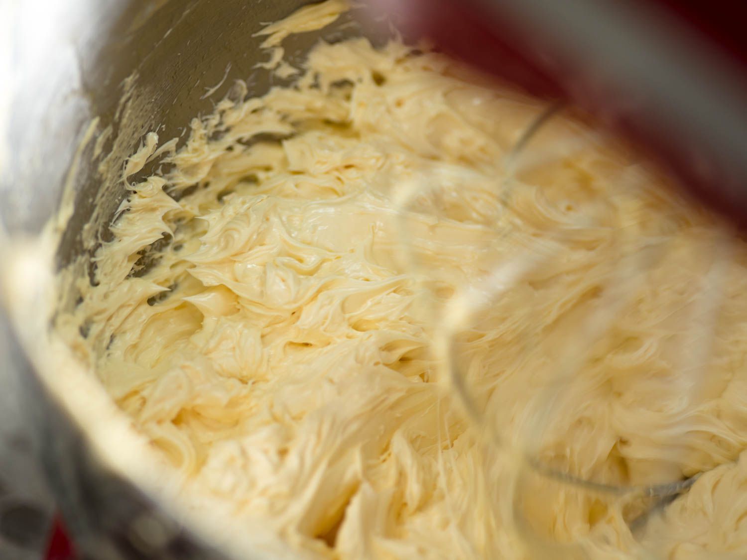 Whipping French buttercream until thick and fluffy.