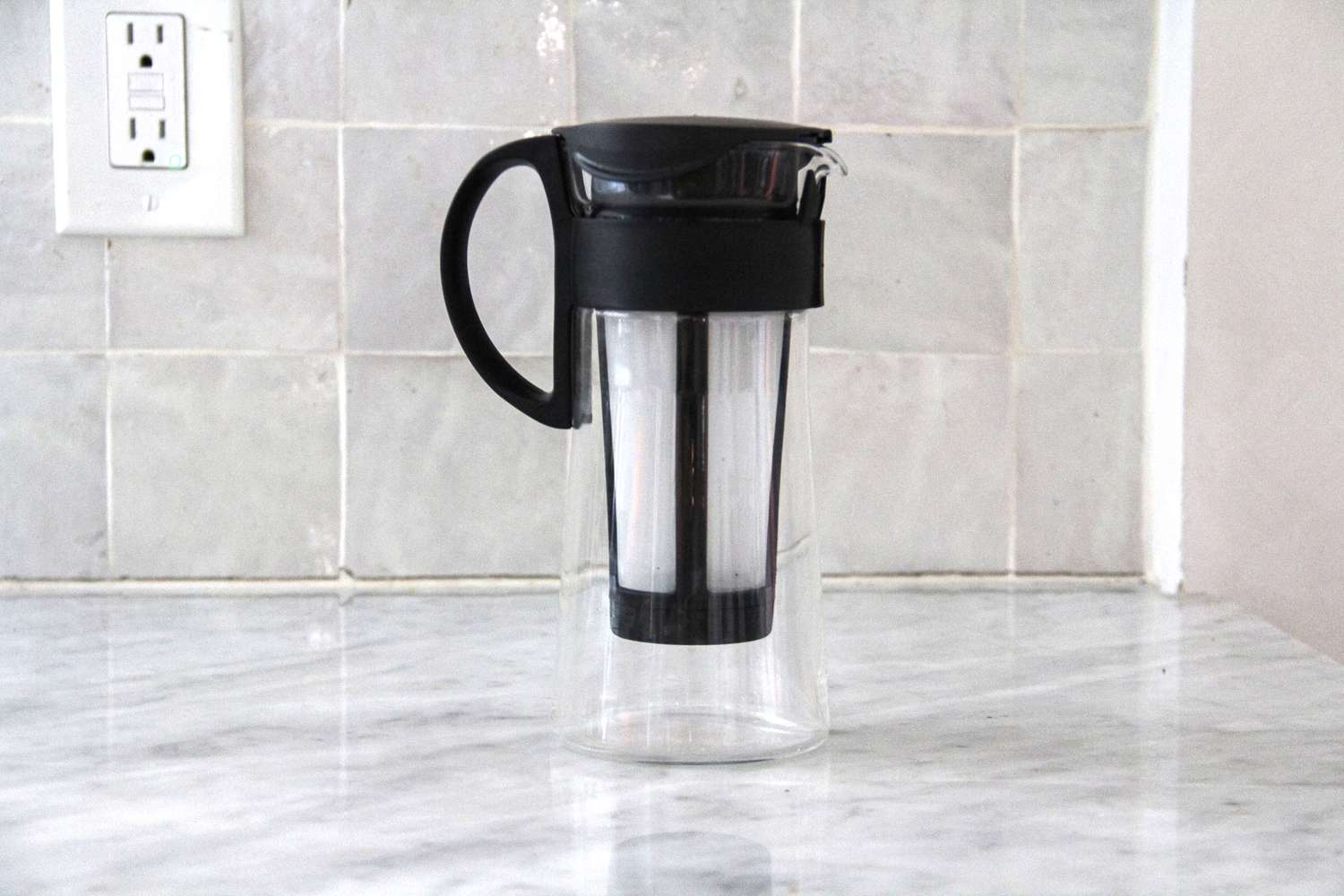 The Hario cold brew maker on a marble kitchen countertop.