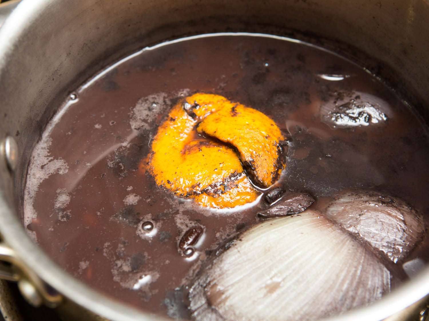 Black bean simmering in cooking liquid, which has reduced.